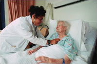 Picture of an elderly woman in a hospital bed with a doctor listening to her heart, which pertains to heart attack hospitalization information.